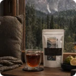 Tasse Earl Grey Tee neben loser Teemischung von MEE KAFFEE mit Schwarztee, Bergamotte, Kornblüten und Zitrusschalen – aromatische Zutatenkomposition für klassischen Teegenuss und entspannte Genussmomente
