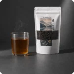 Loser Earl Grey Schwarztee von MEE KAFFEE neben einer frisch aufgebrühten Tasse Tee – klassische Teemischung mit feiner Bergamotte-Note für aromatischen Genuss zu jeder Tageszeit